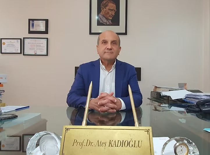 Prof. Dr. Ateş Kadıoğlu seated at his desk in his Istanbul consulting room.